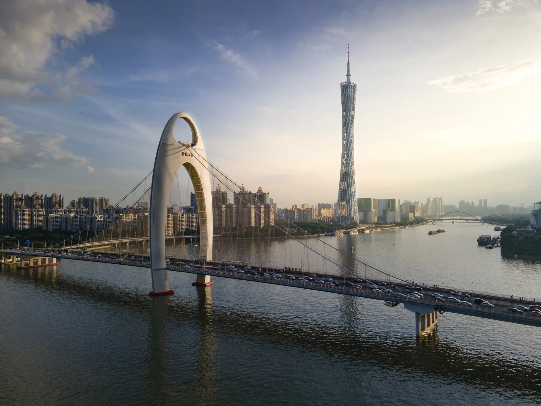 An arched bridge and skyline above a river.