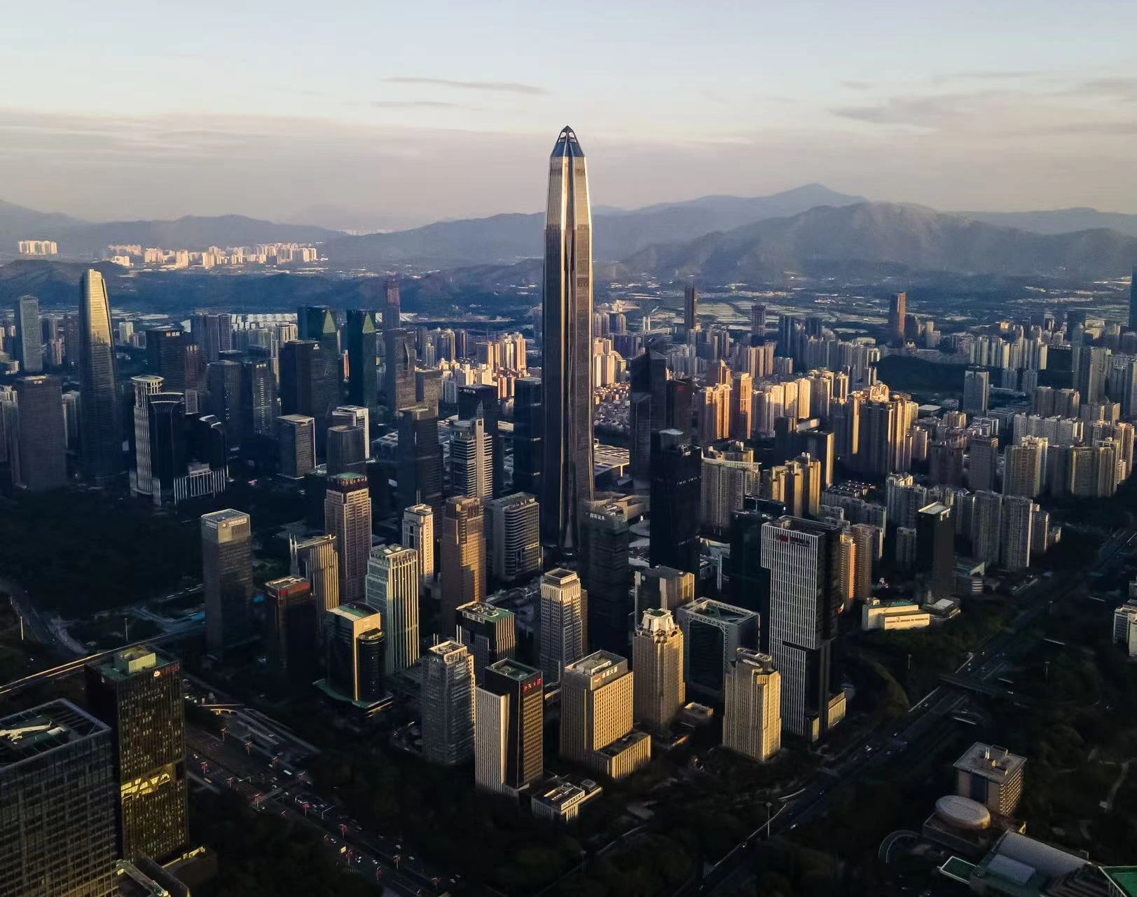 A dense city skyline in warm evening light.