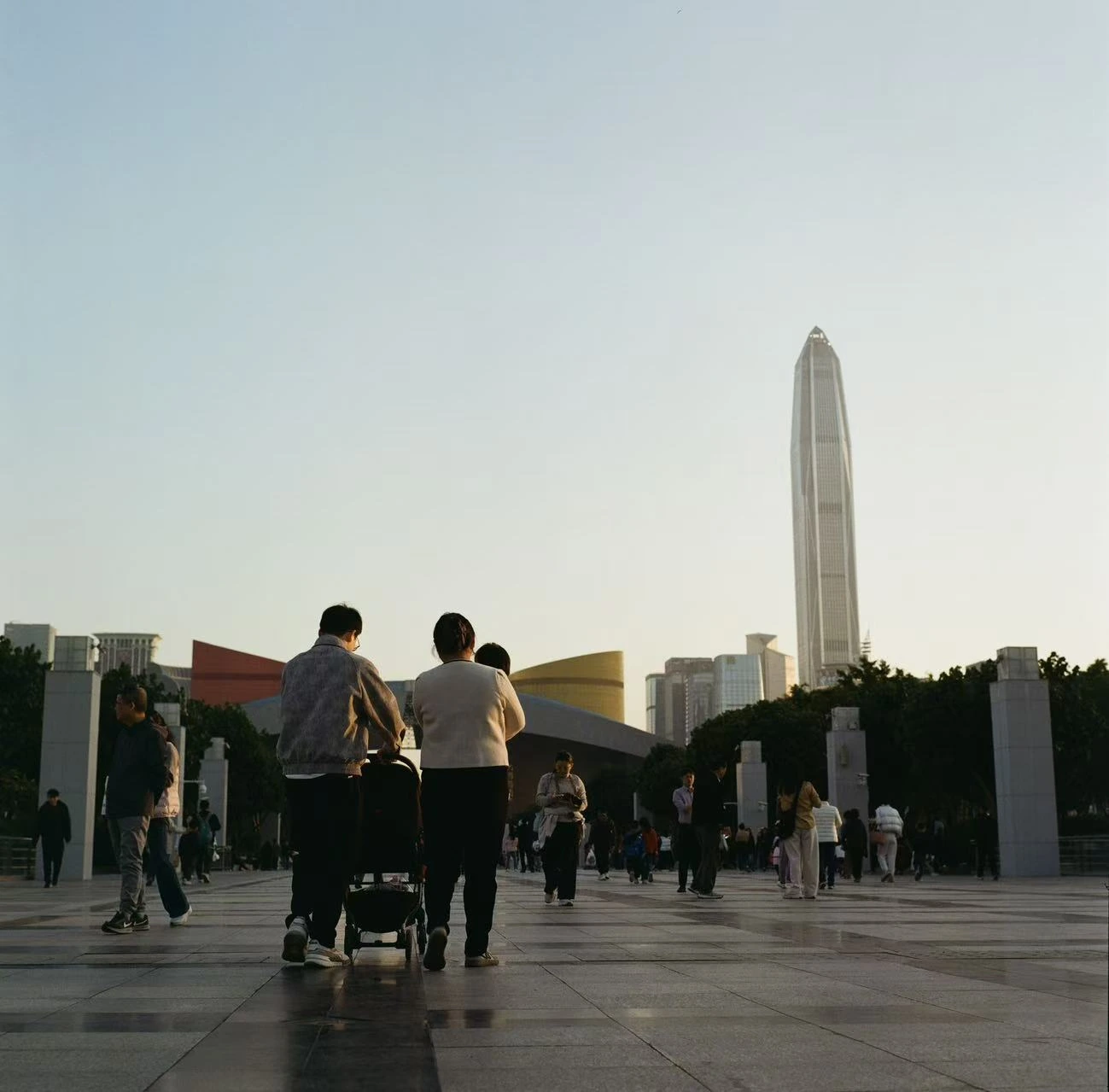 People walking toward a tall tower.