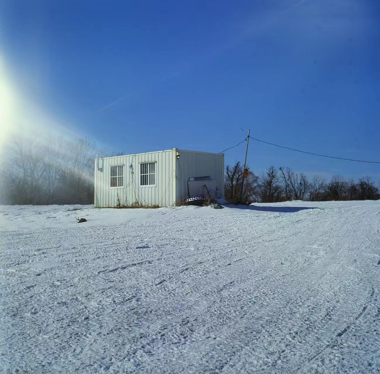 A small white building in a snowy landscape.