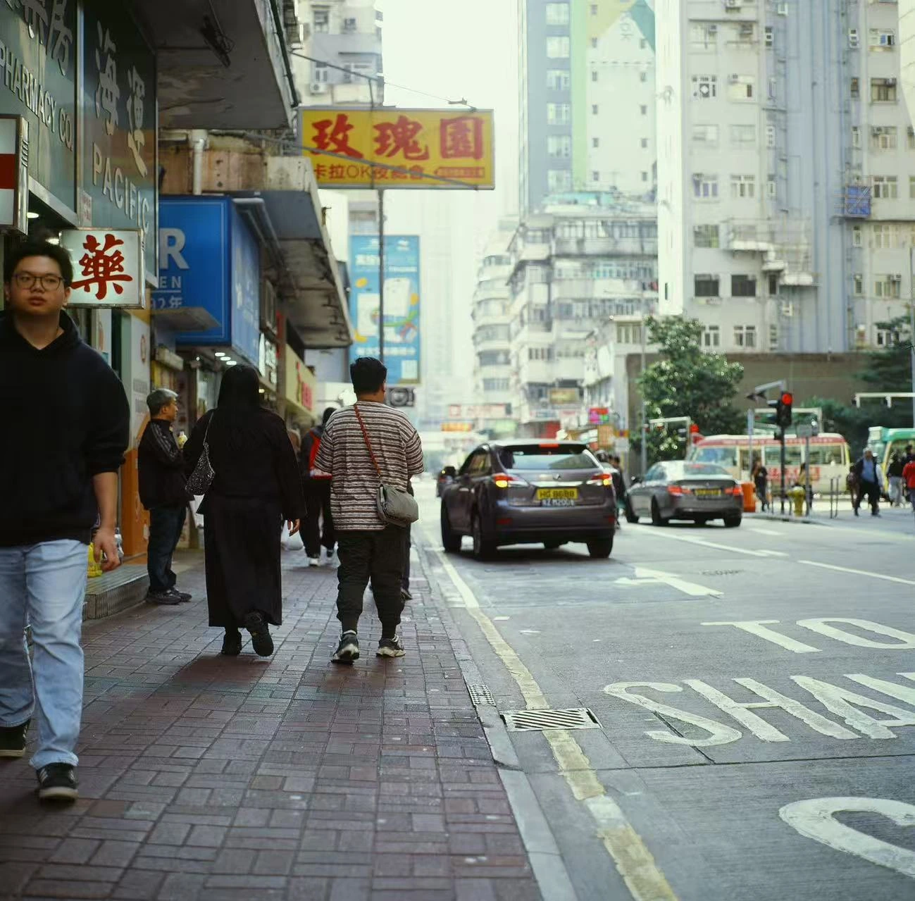 Pedestrians walking along a busy street.