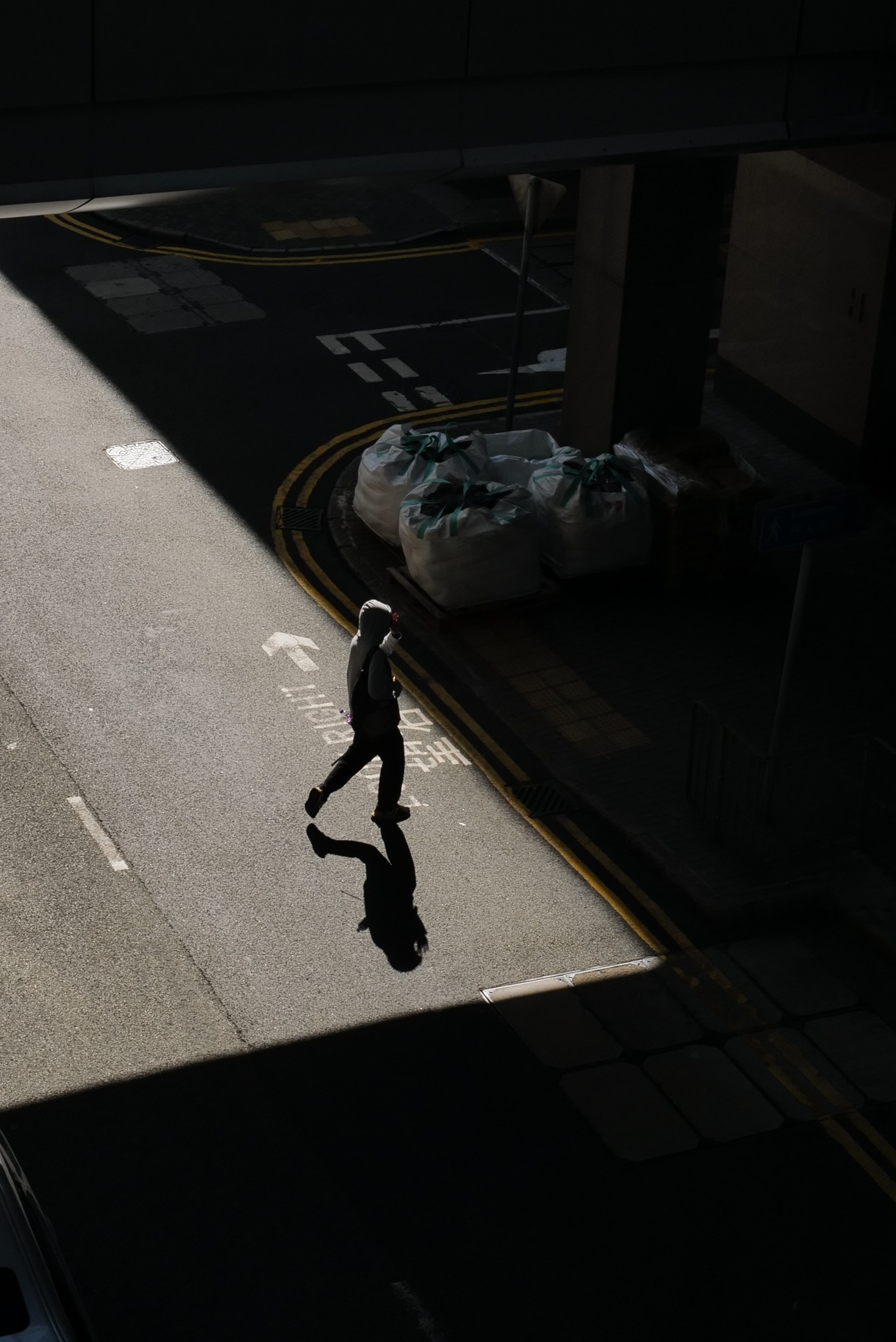A person and a long shadow on a street.